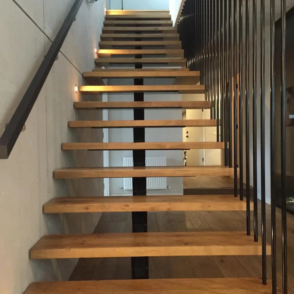 Floating oak treads lit from the wall, with a steel balustrade