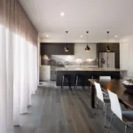Grey oak floor in a dining and kitchen area with sheer curtains