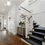 Toran Reclaimed Oak hallway beside a white staircase with a dark runner