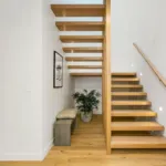 Open-riser oak staircase in a white stairwell