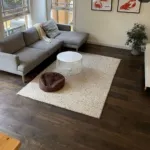 Constantine Oak dark floorboards in a living room with a grey modular sofa