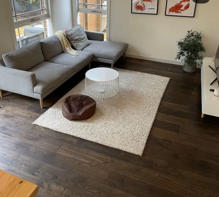 Constantine Oak dark floorboards in a living room with a grey modular sofa