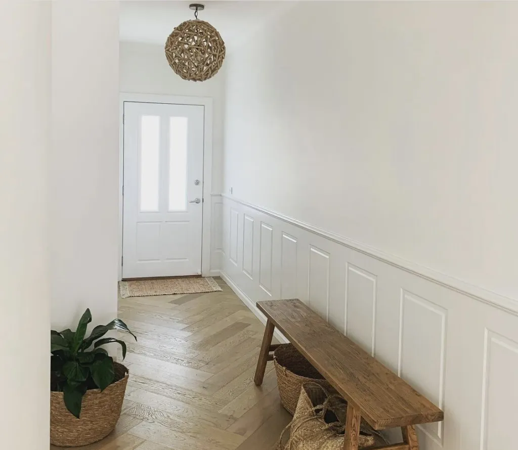 Fiord Oak herringbone in an entry hall with a timber bench and wainscoting