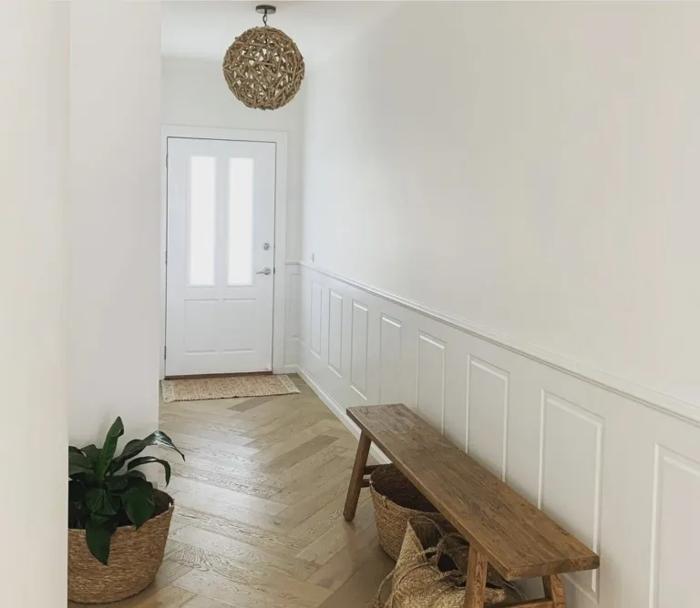 Fiord Oak herringbone in an entry hall with a timber bench and wainscoting