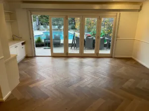 Sherbrooke Oak herringbone floor in a family room opening to the pool through timber French doors