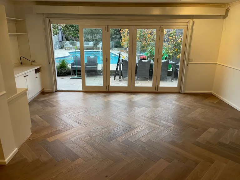Sherbrooke Oak herringbone floor in a family room opening to the pool through timber French doors