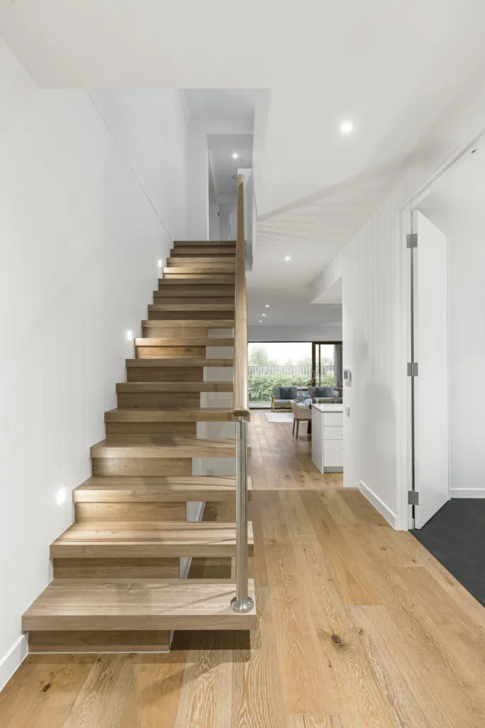 Floating oak staircase in a bright entry