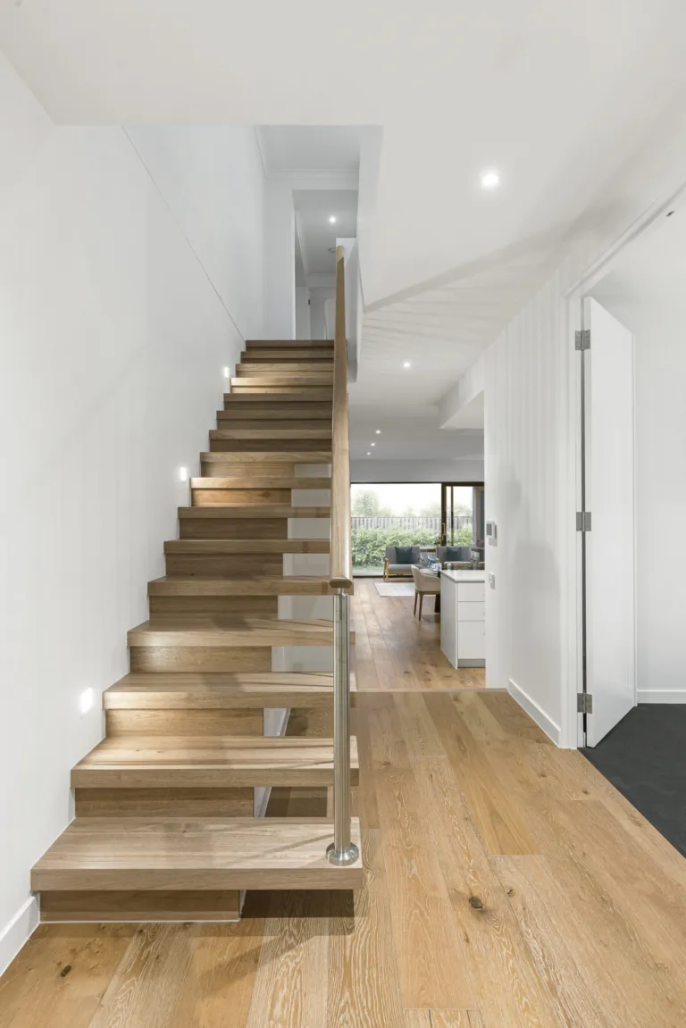 Floating oak staircase in a bright entry