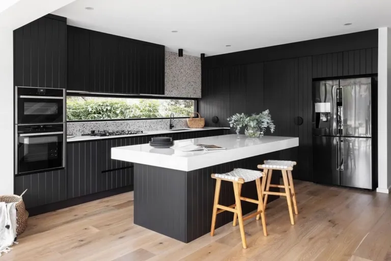 Oak floor in a black kitchen with a white island bench