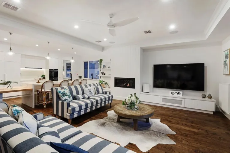 Reclaimed oak floor in a family room with a fireplace and striped sofas