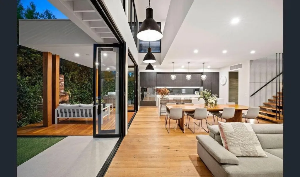 Light oak open-plan living opening to a garden through wide stacker doors