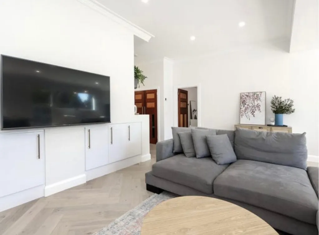 Vermont Oak herringbone parquetry in a living room with a grey sofa and white joinery
