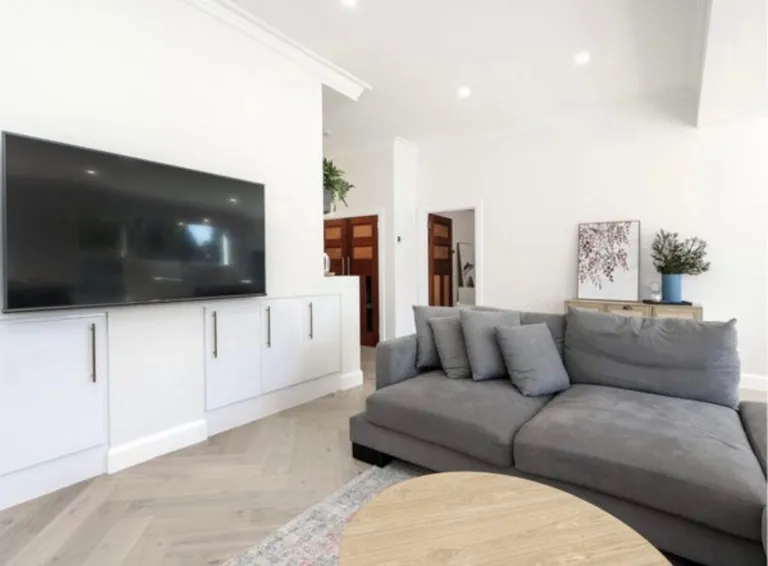 Vermont Oak herringbone parquetry in a living room with a grey sofa and white joinery